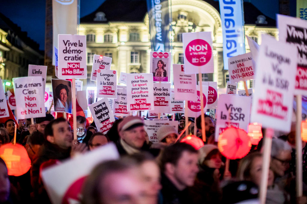 a picture of a crowd holding up posters