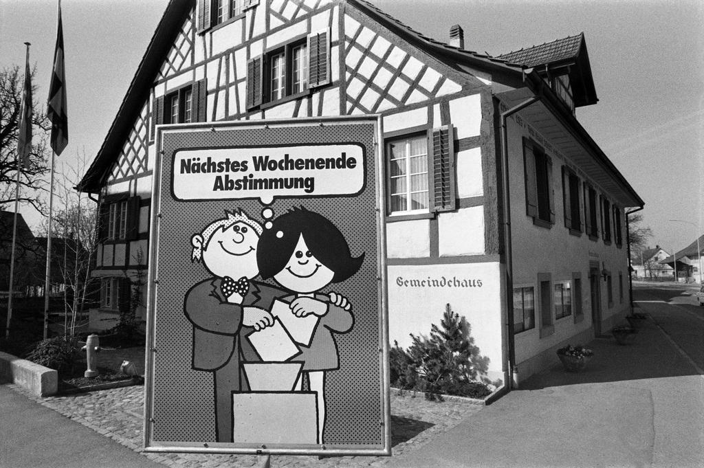 Gemeindehaus mit Plakat, das auf den kommende Abstimmungssonntag hinweist.