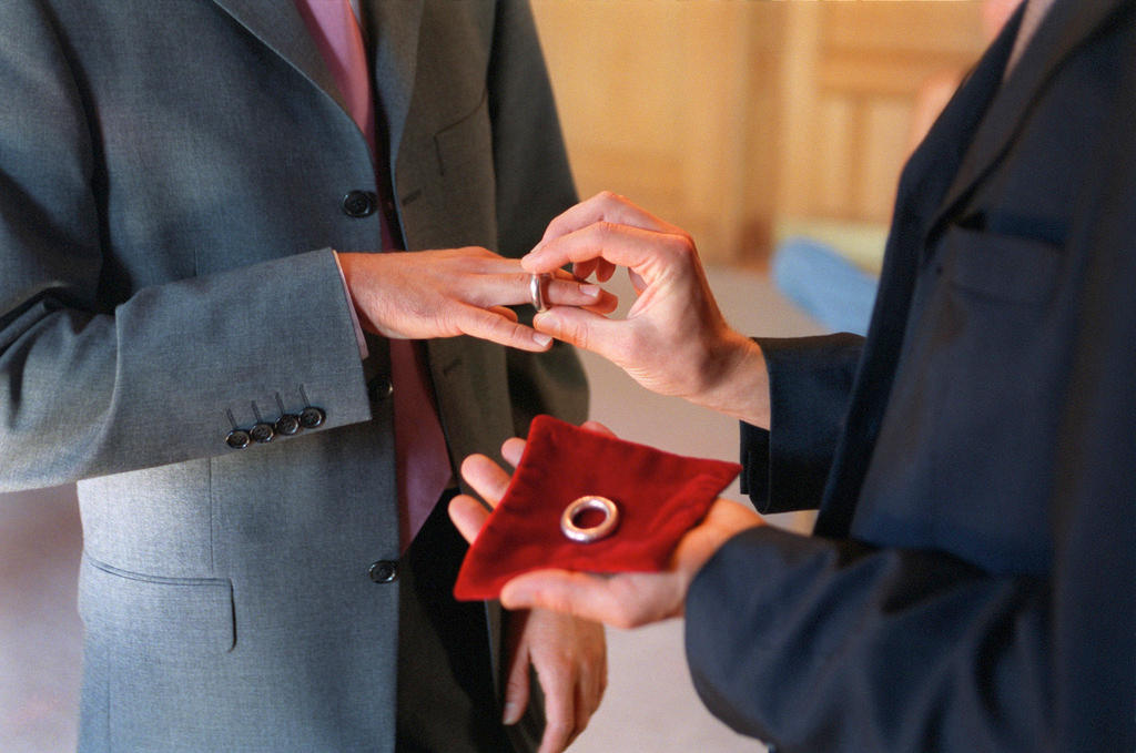 pareja de hombres intercambia anillos de compromiso.