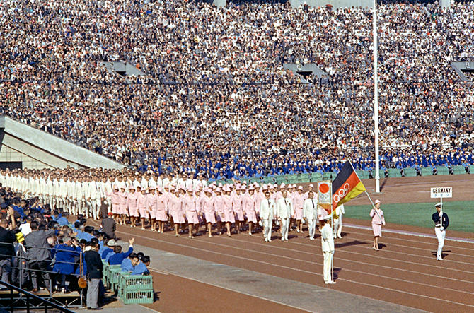 Siflata degli atleti in uno stadio affollatissimo.