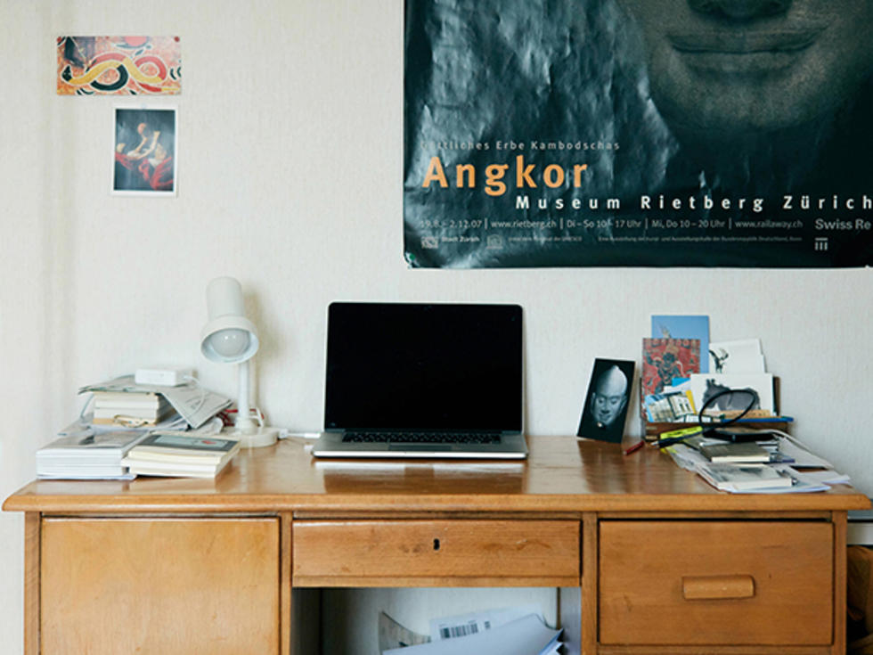 Ein Holztisch mit einem Laptop und einer Lampe.