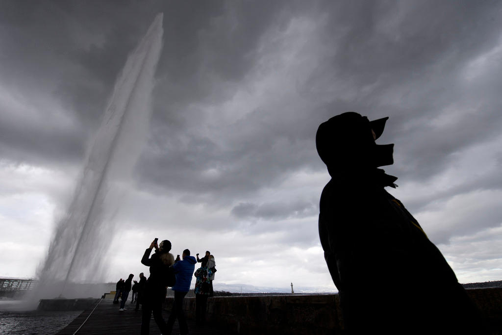 Geneva fountain with tourists and shadowy figure