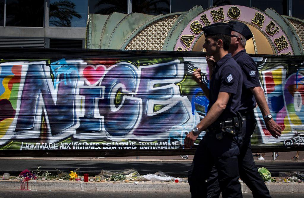 Police pass a graffiti honouring the victims of the Nice attack