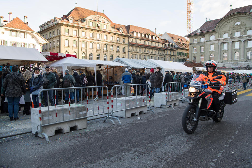 Picture of a police man on a motorcycle alongside concrete blocks to protect the traditional onion market in Bern.