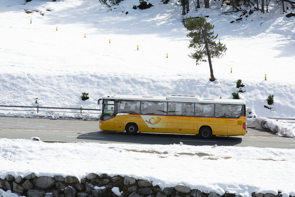 Un pullman in di autopostale in viaggio in un paesaggio innevato
