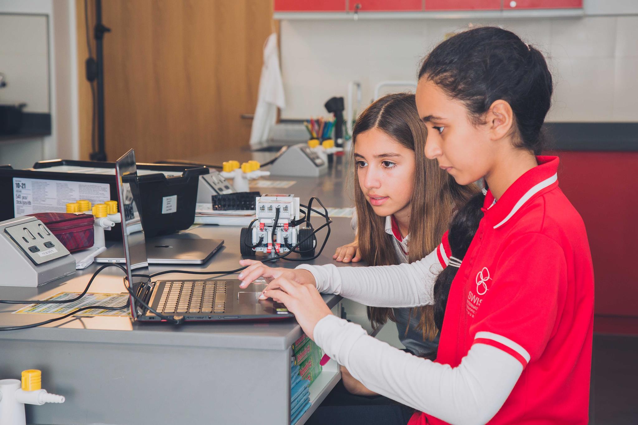 Two young students in front of a laptop