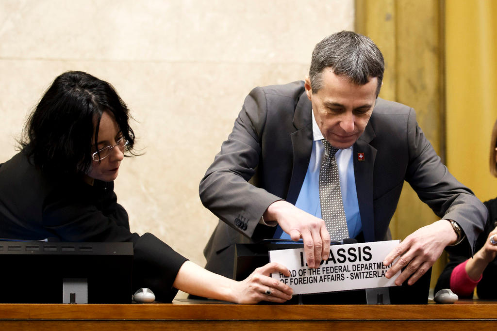 ignazio cassis mentre sistema la placchetta con il suo nome su un tavolo