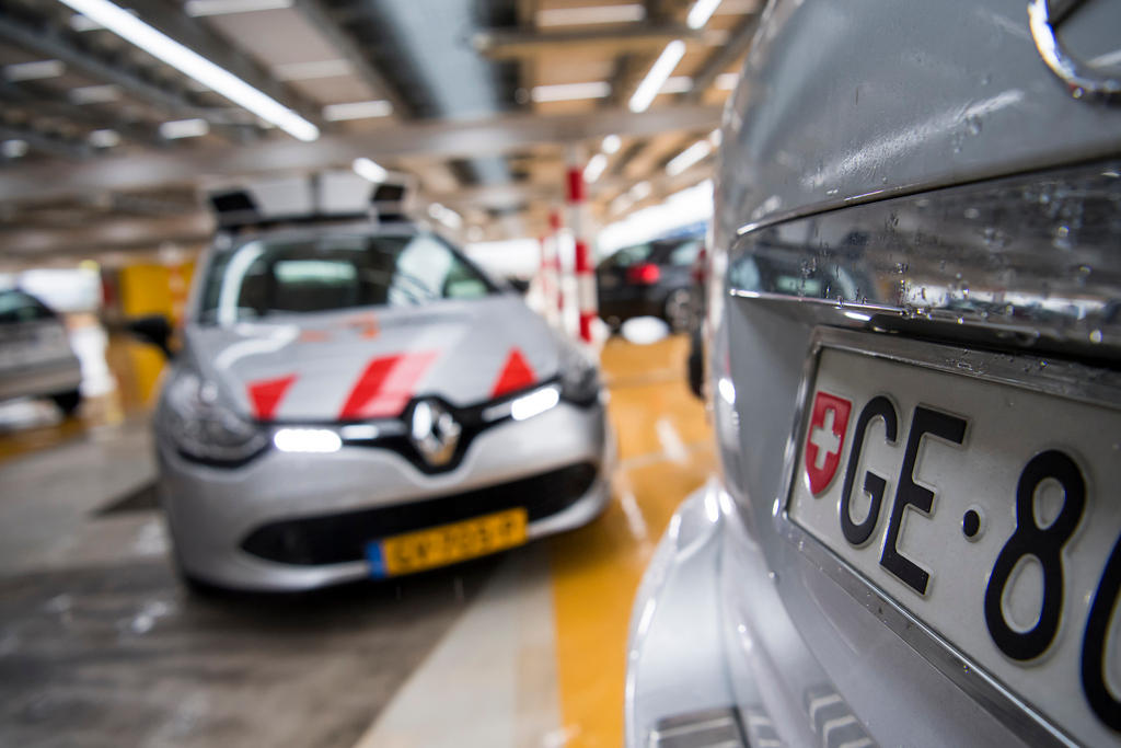 Un automobile con due telecamere sul tetto si aggira per un parcheggio sotterraneo