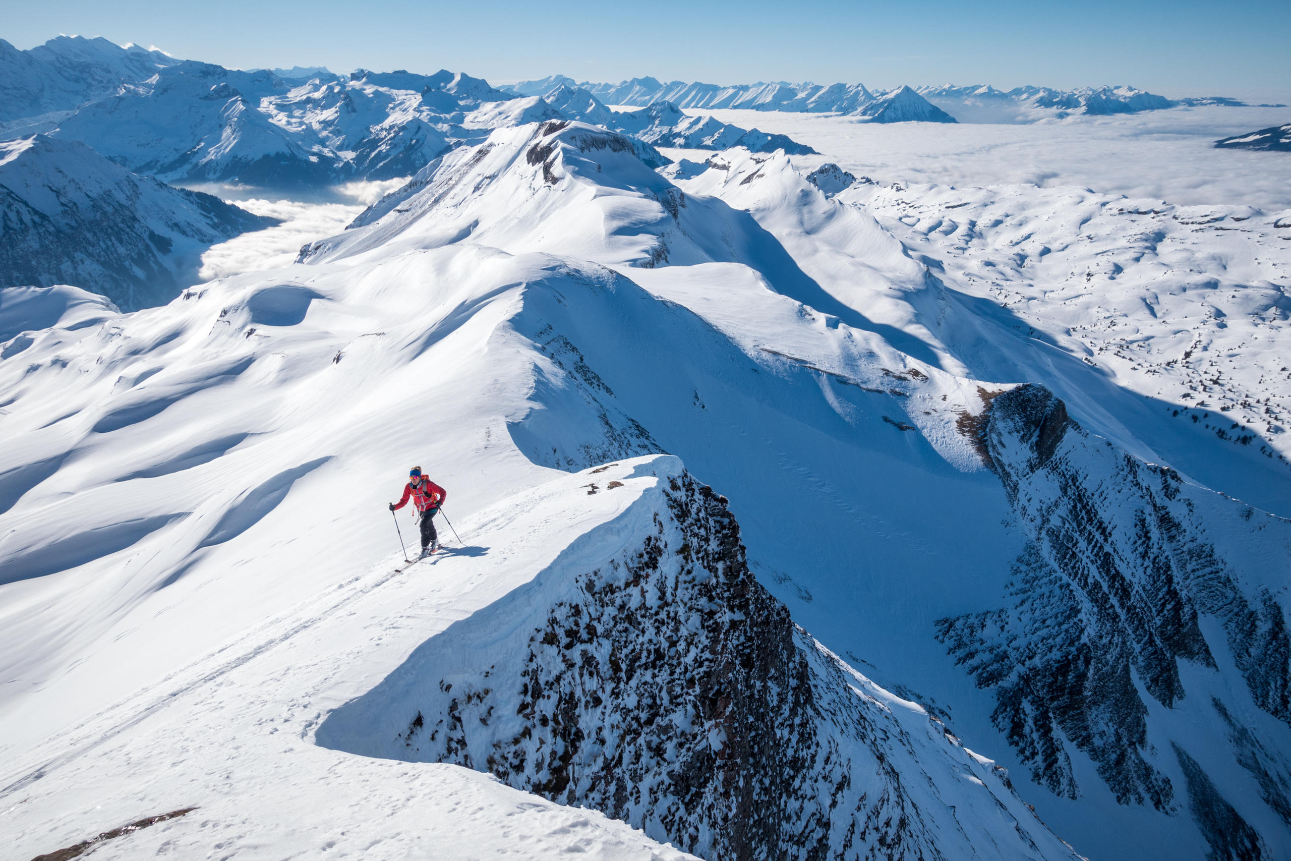 Ski tourer walking along mountain ridge