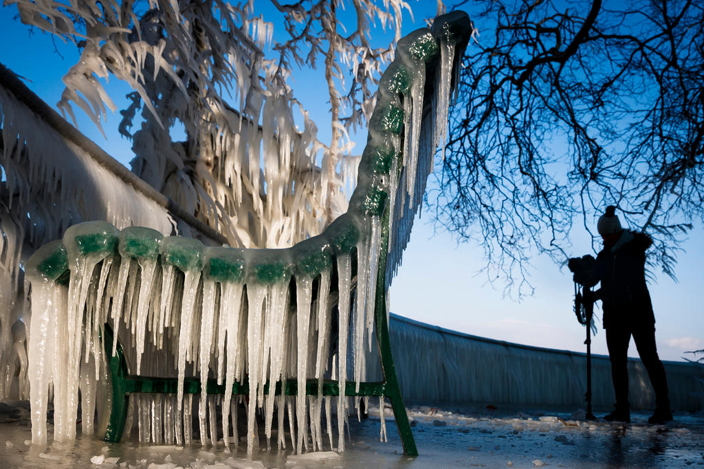 Un paseante filma las caprichosas formas del hielo sobre una banca