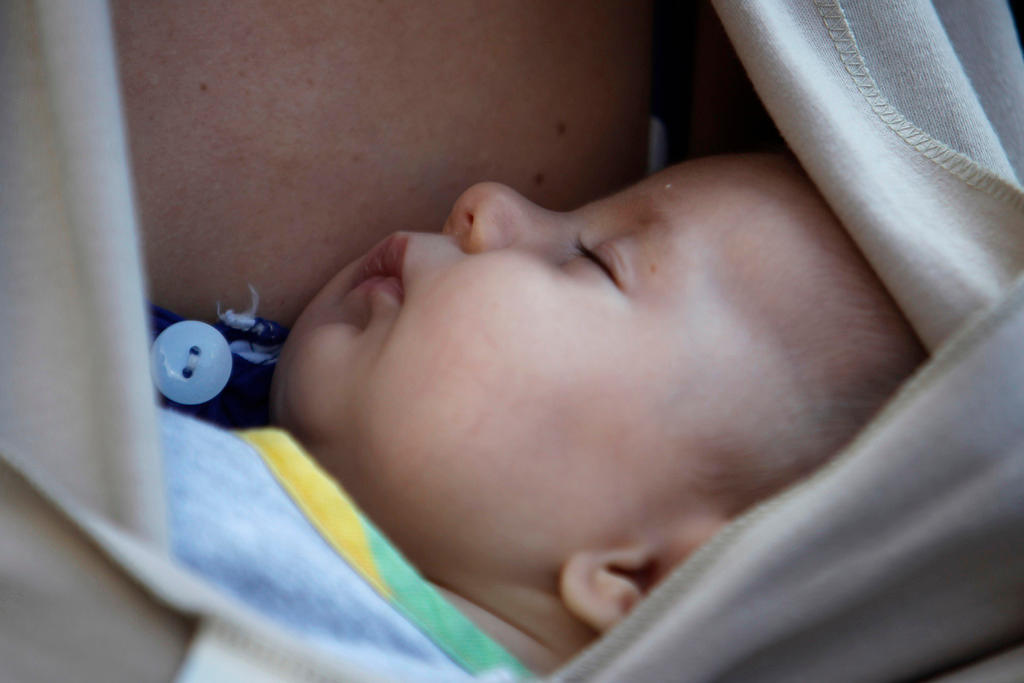 baby sleeping against mother s breast