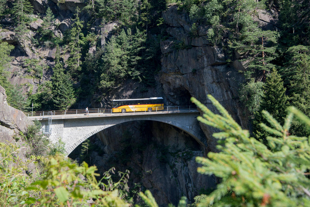 Yellow PostBus on mountain bridge
