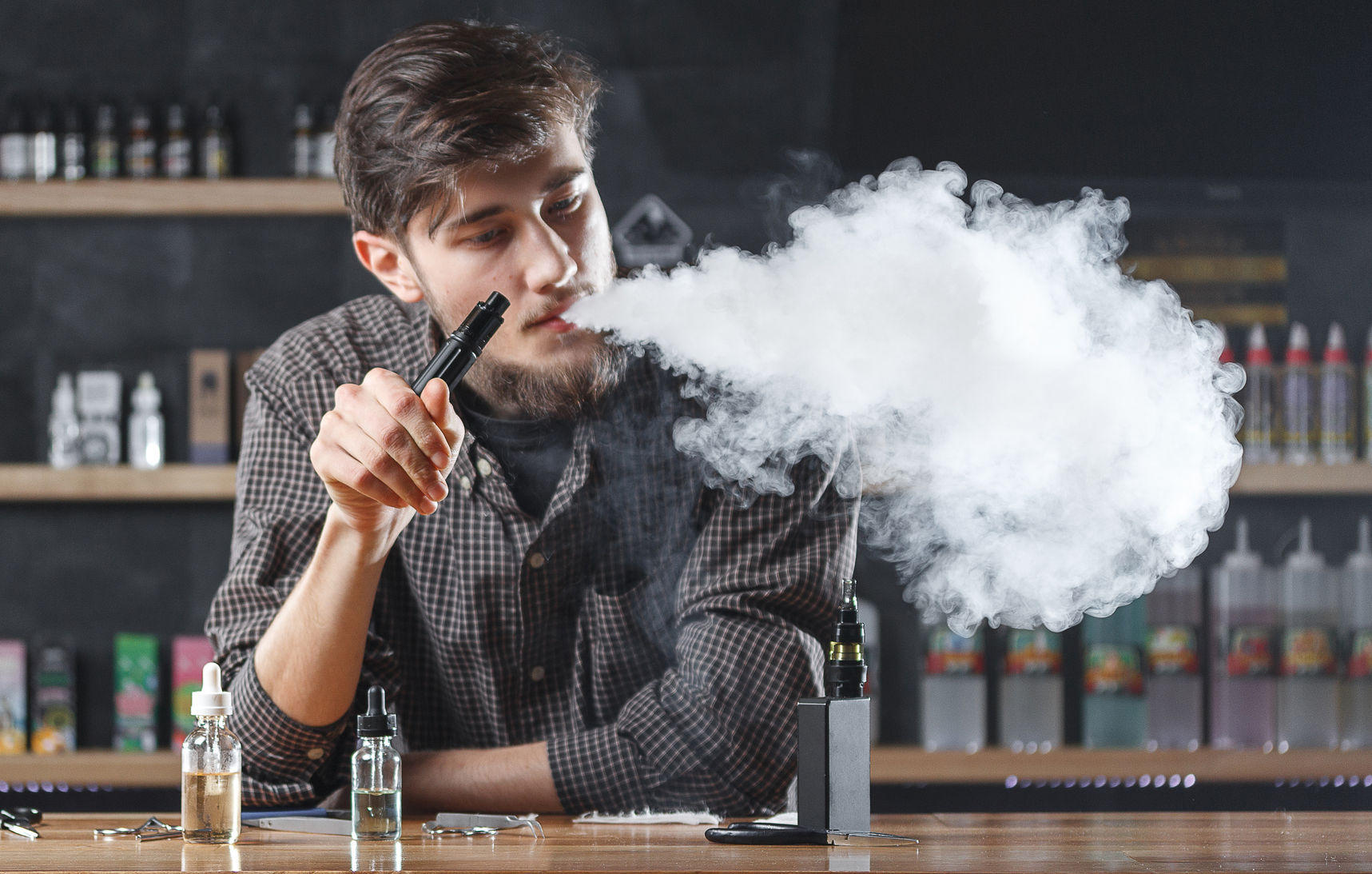 Un homme fume un cigarette électronique