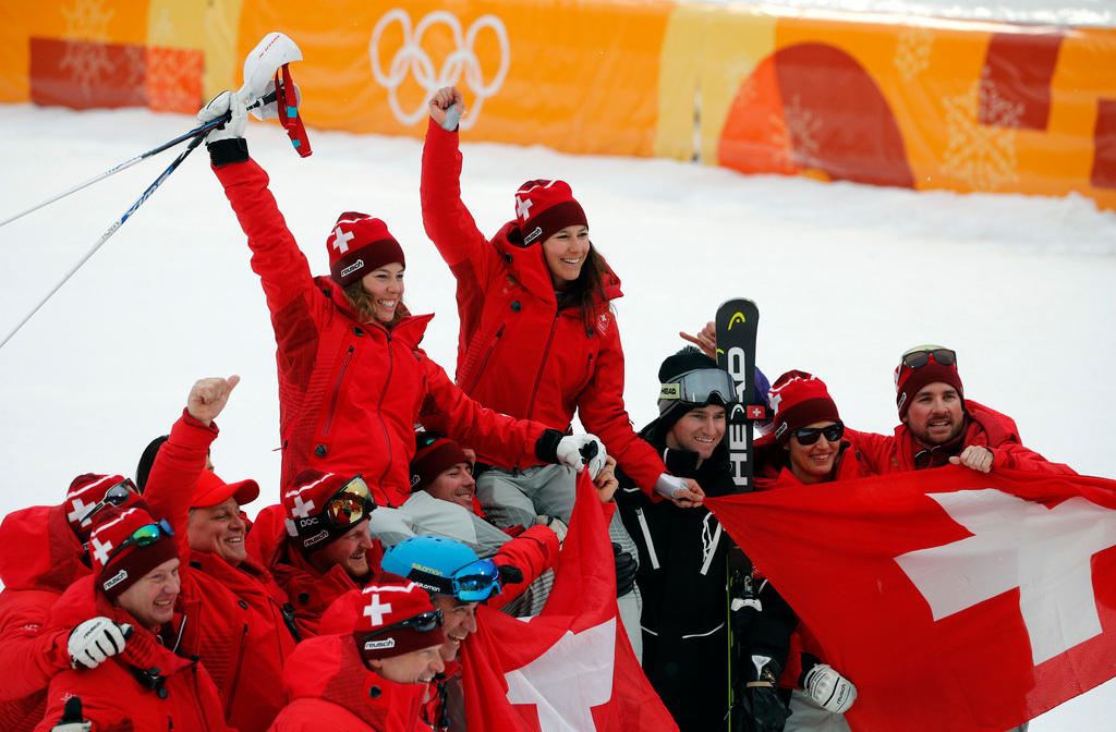 Switzerland s Michelle Gisin, left, gold, and Switzerland s Wendy Holdener, bronze, are hoisted aloft by team members.