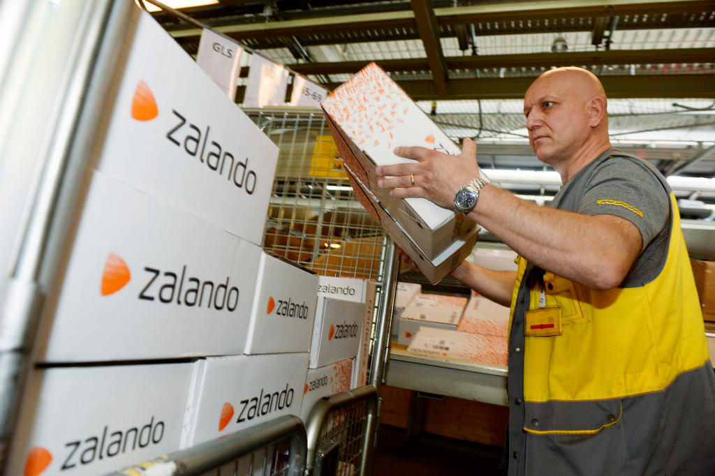 impiegato della posta con in mano dei pacchetti zalando