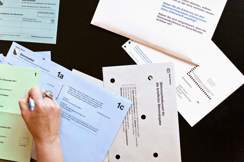 A woman fills out a vote-by-mail ballot