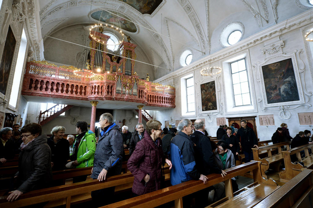Immagine dell interno della chiesa parrocchiale di Bürglen con fedeli che si alzano alla fine di una funzione