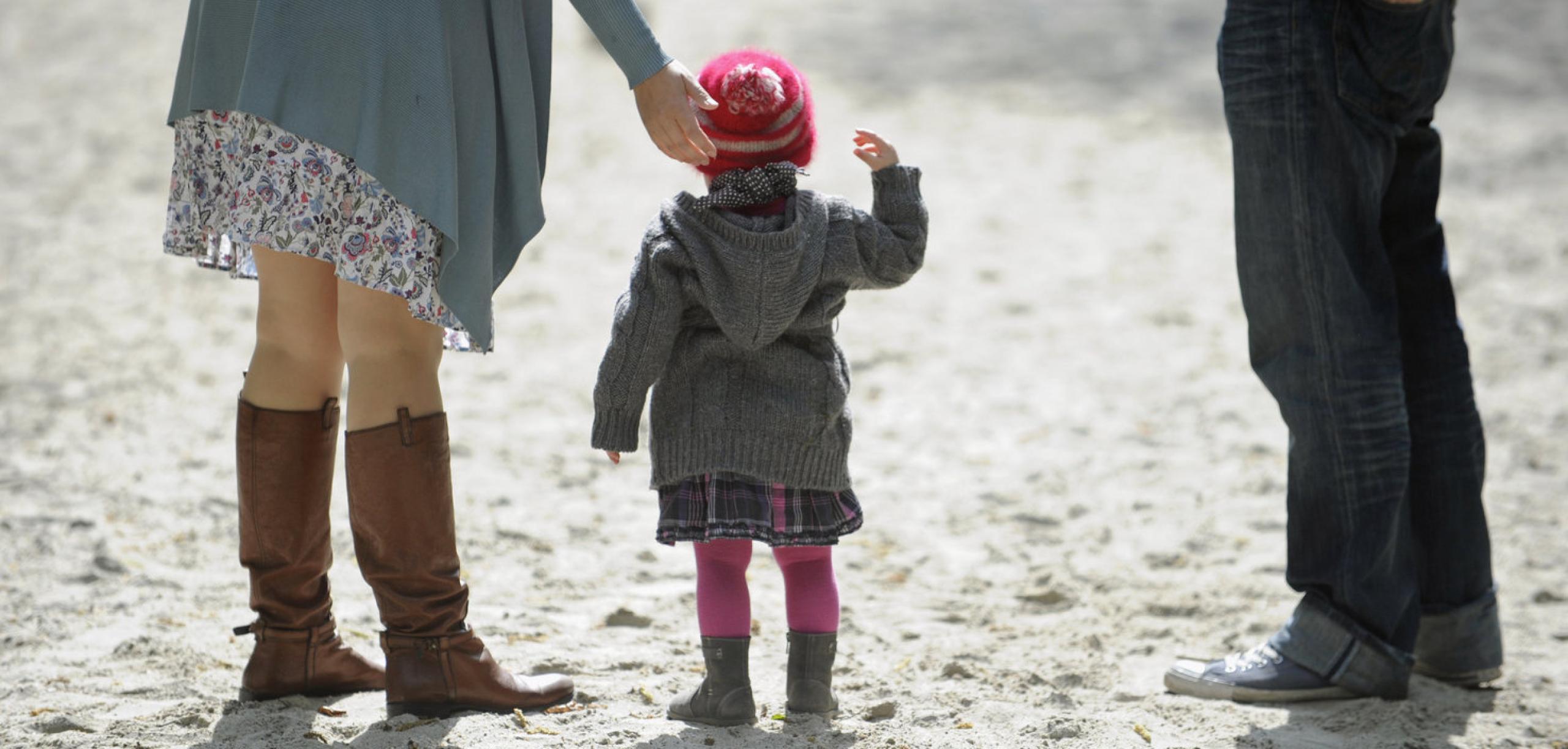 Ein Kind mit Vater und Mutter am Strand