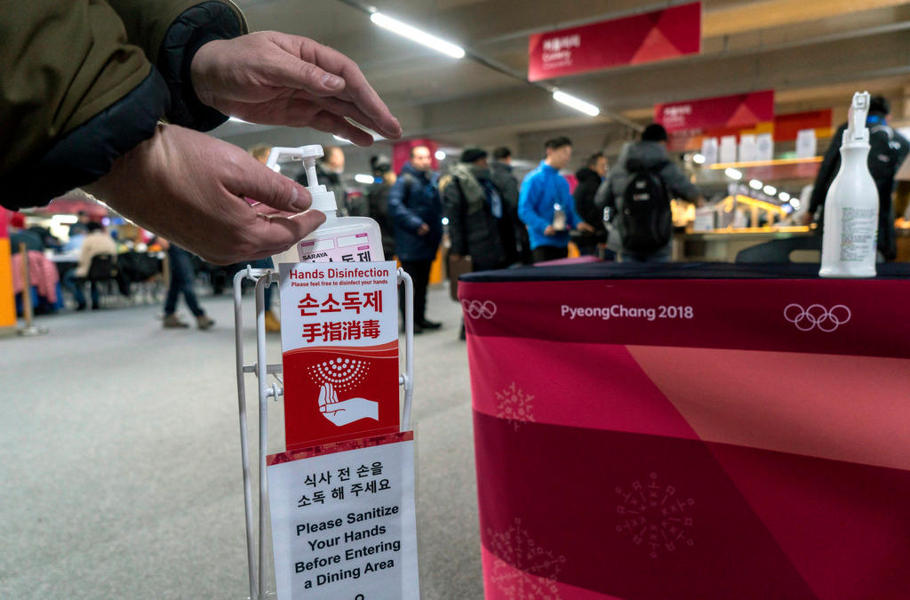 a man sanitizes his hands at the entrance to the media cafeteria, in Gangneung, South Korea.