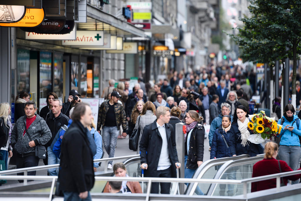 A picture of a man on crutches in a crowd.