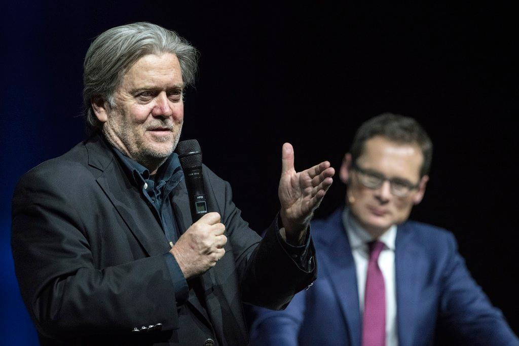 Steve Bannon speaks into a microphone, with Roger Koeppel in background