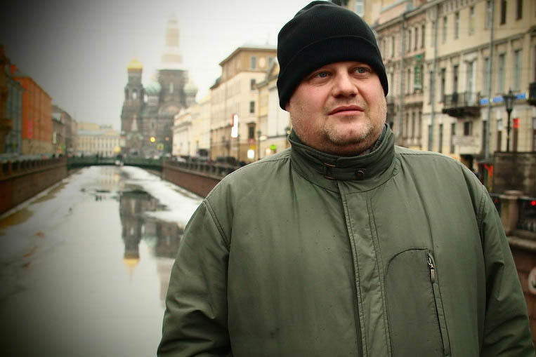 man in front of a canal and church