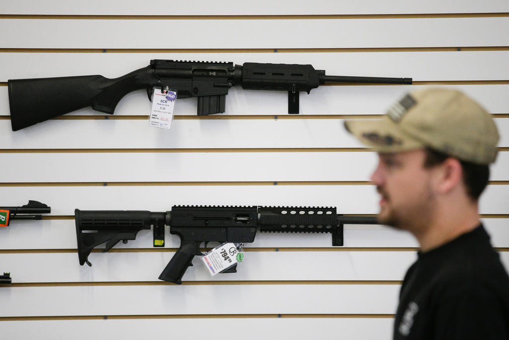 Two guns hang on the wall in a shop