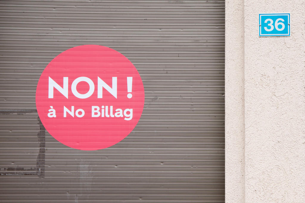 Runder, roter Kleber mit Aurschrift NON! à No Billag auf einem Garagentor