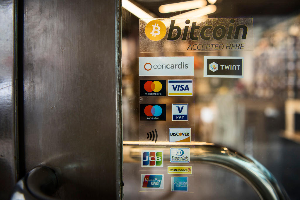 Bitcoin sticker together withe other payment options on a shop door