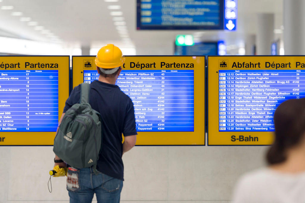 A commuter studies an electronic timetable at Loewenstrasse train station in Zurich Main Station, Switzerland