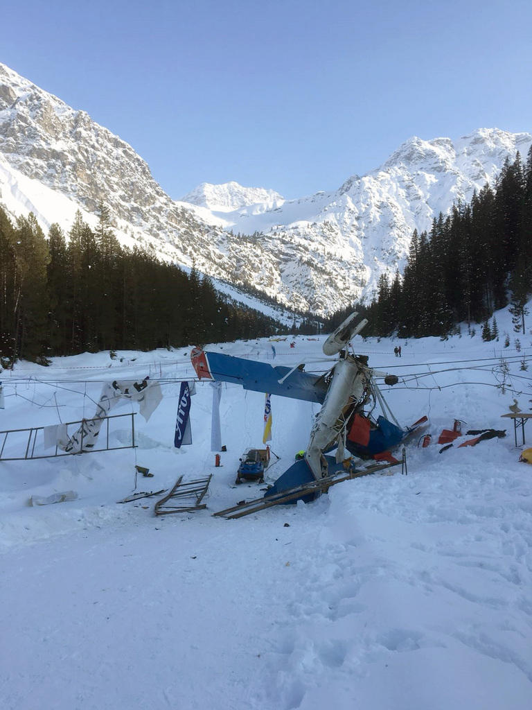 Crashed aircraft on snow with mountains in the background