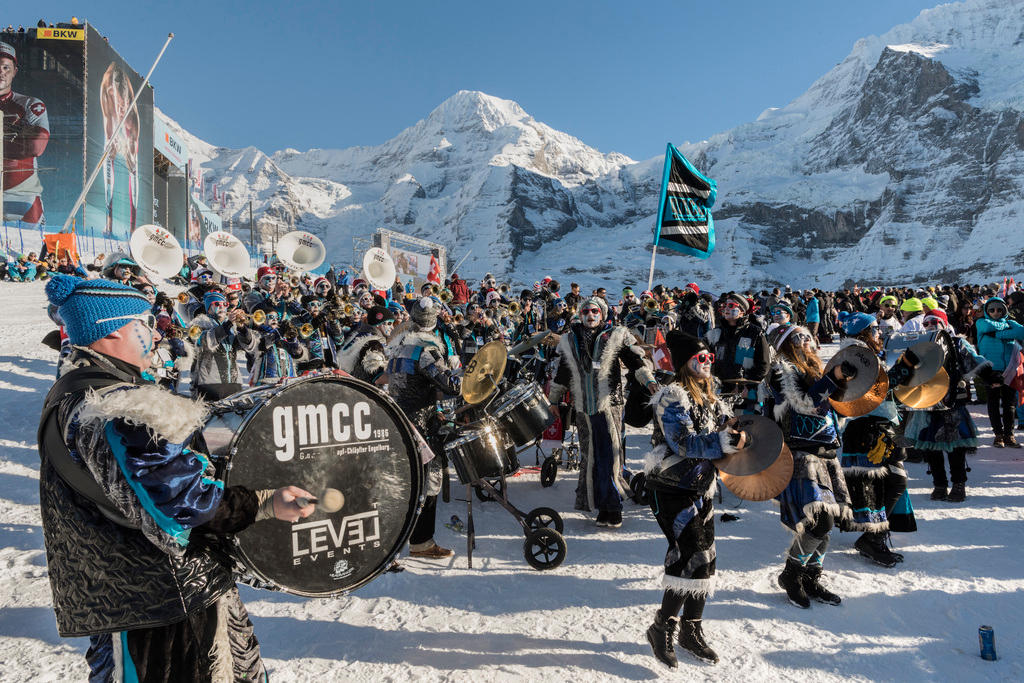 People in carnival costumes with snowy peaks in background