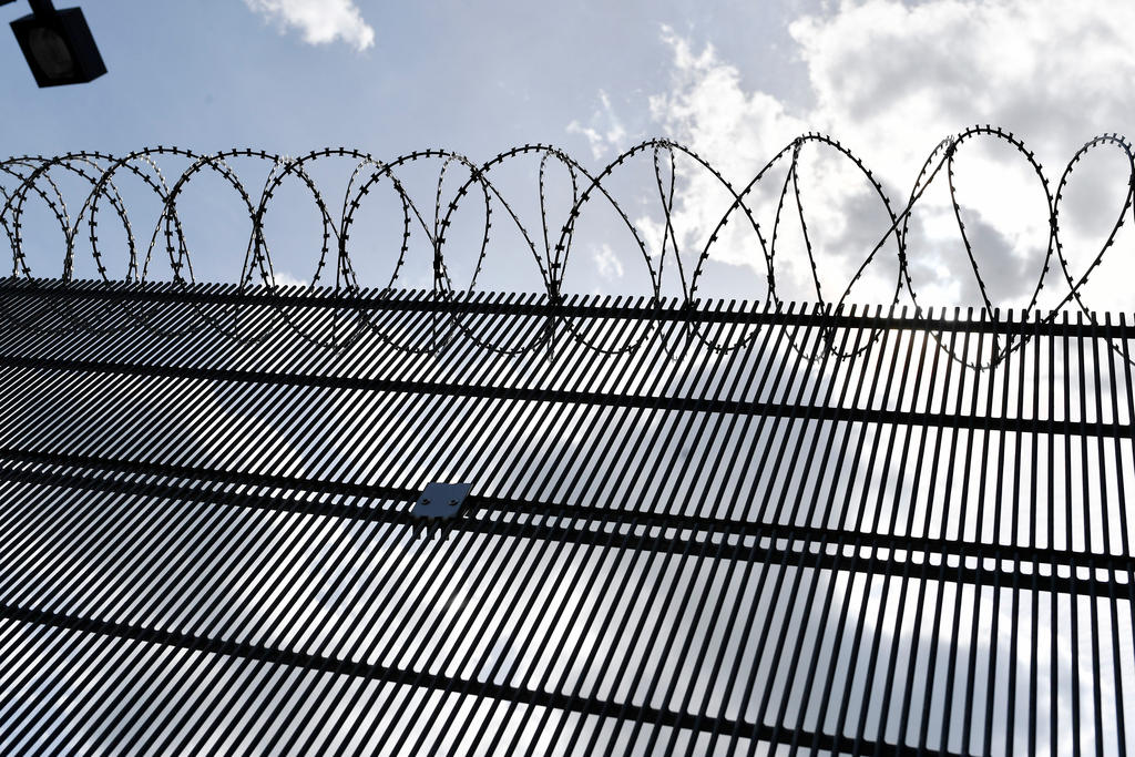 Stacheldraht bei Gefängnismauer