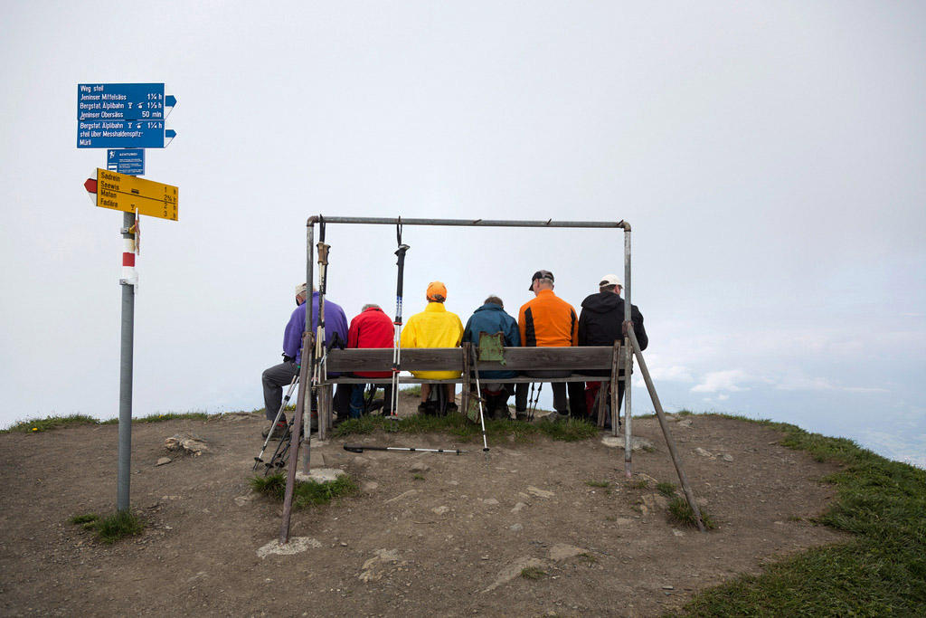 escursionisti seduti su una panchina in cima a una montagna