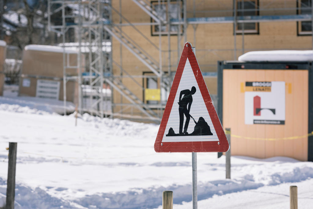 A building sign outside of a snowy construction site