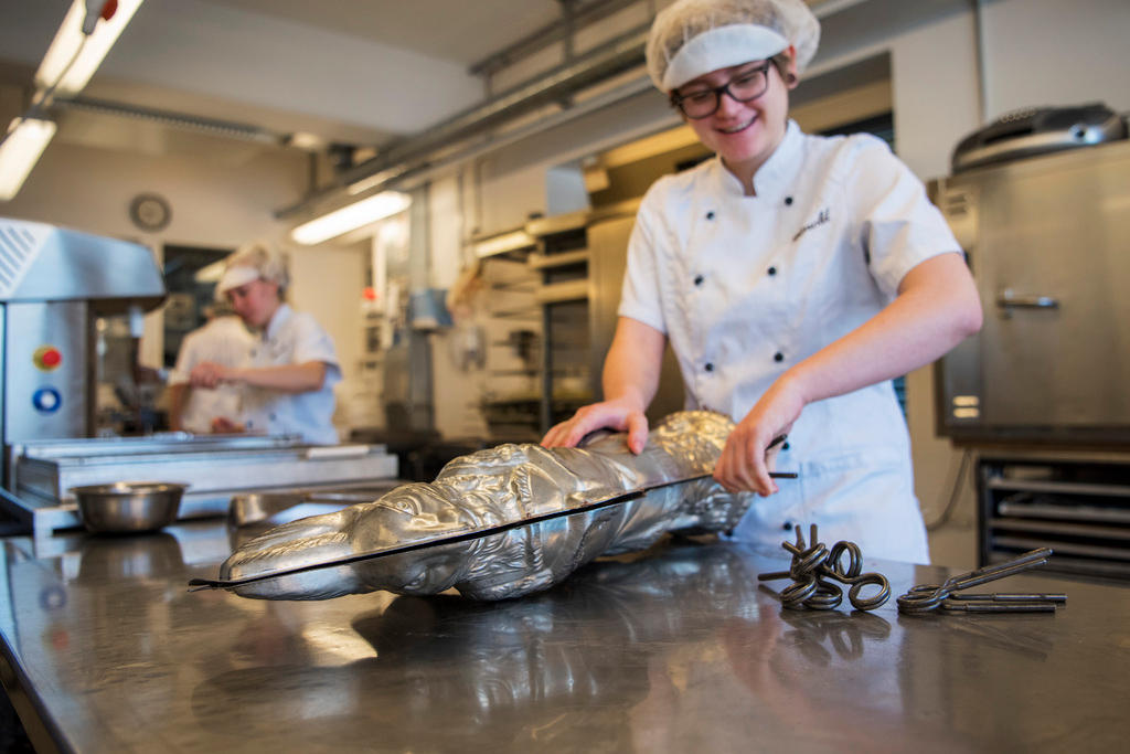 Une femme ferme les moules avec une grande pince.