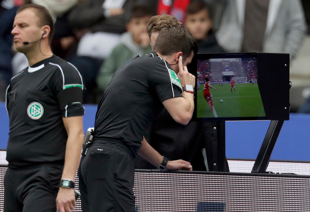 A referee consults a video during a Bundesliga match in Germany