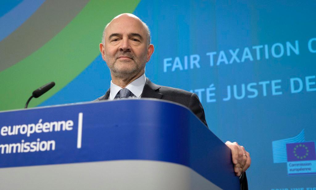 Moscovici parla alla stampa dal pulpito della Commissione. Sullo sfondo, la scritta Fair taxation