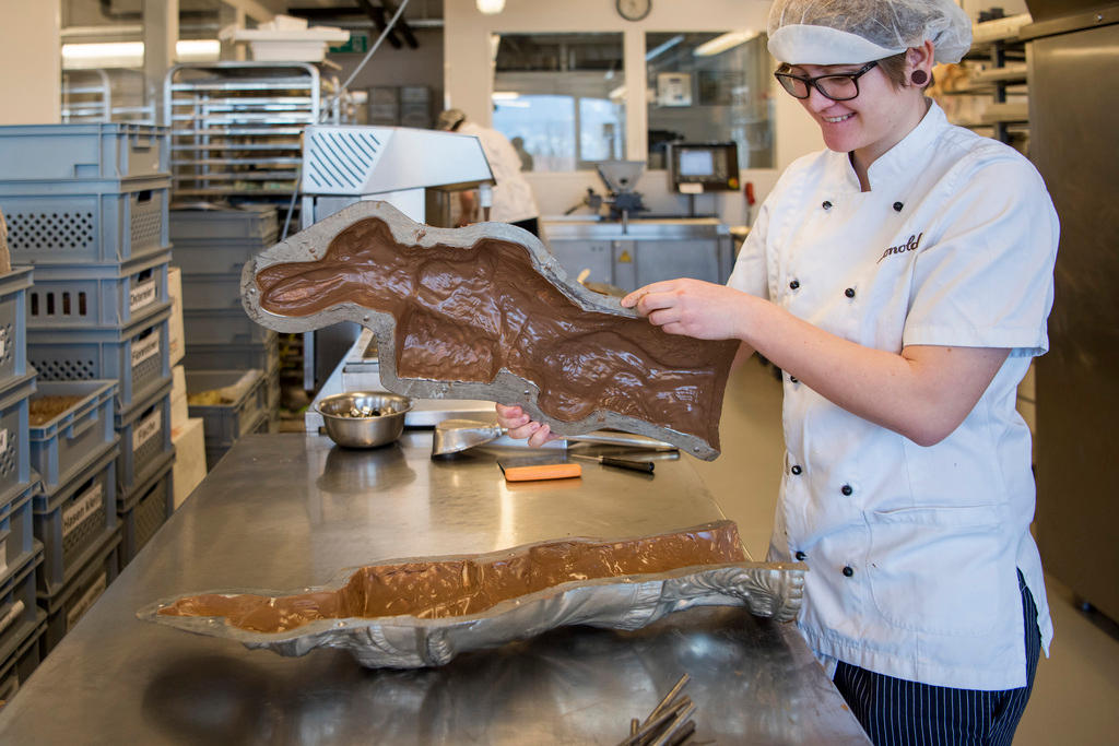 Une femme ferme les moules en chocolat.