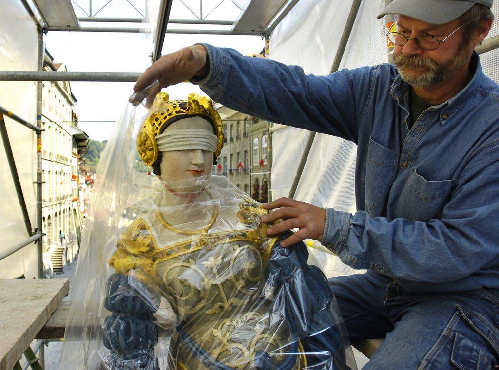 Ein Mann packt eine Statue der Justitia ein