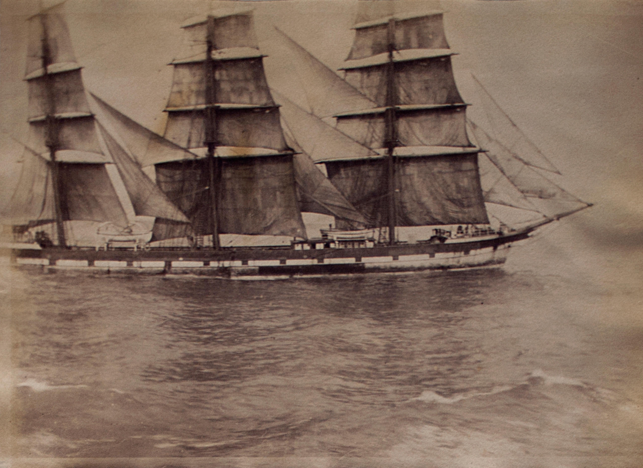 An old picture of a ship at sea.