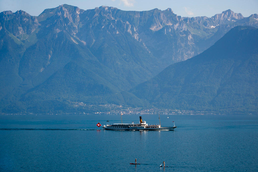 barco de turismo num lago com montanhas ao fundo