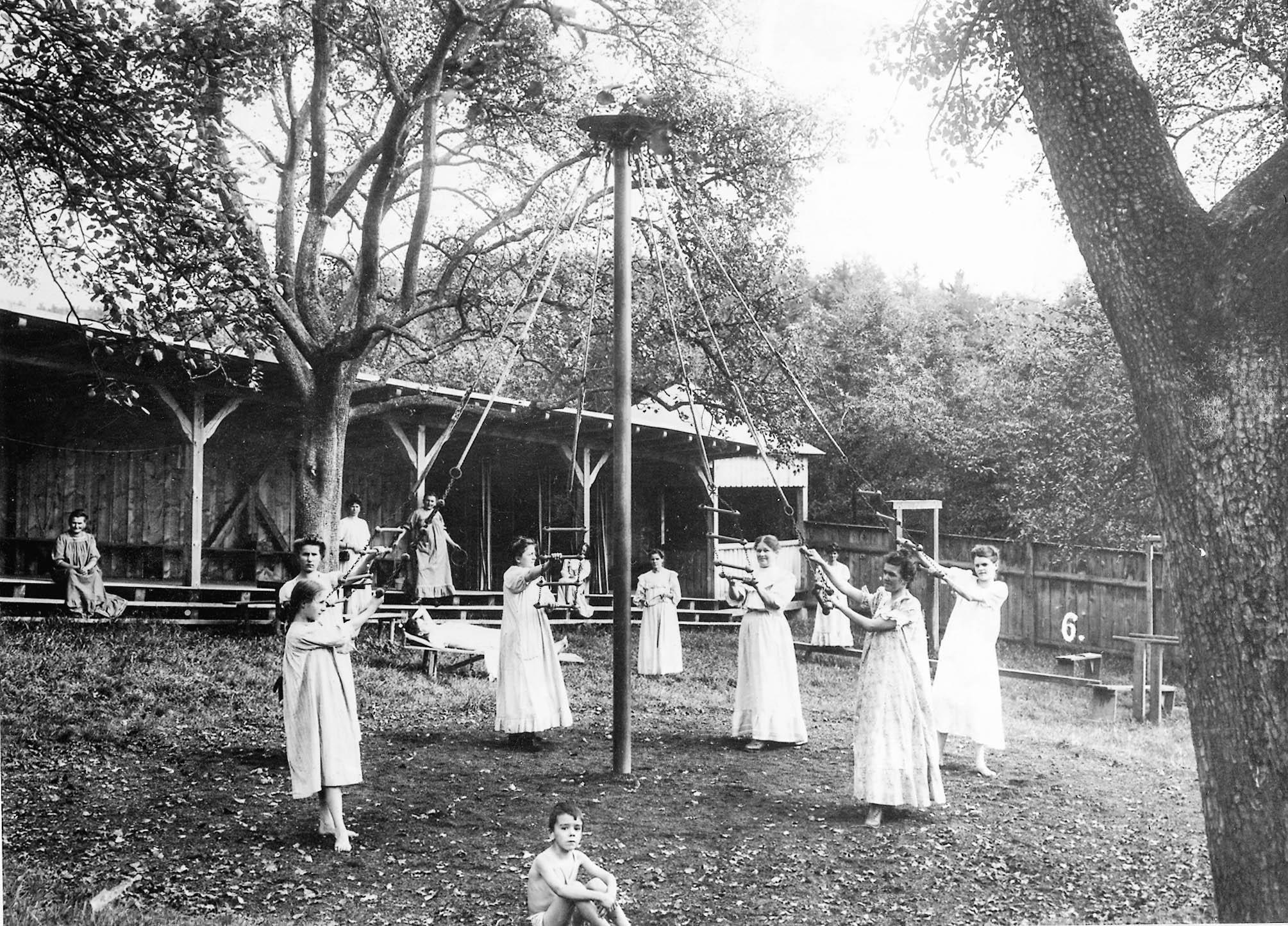 Young women dance around a maypole