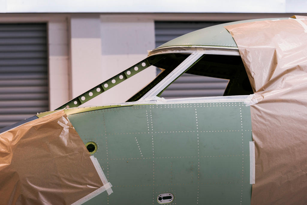 Abgeklebtes Cockpit eines Jets in der Montagehalle