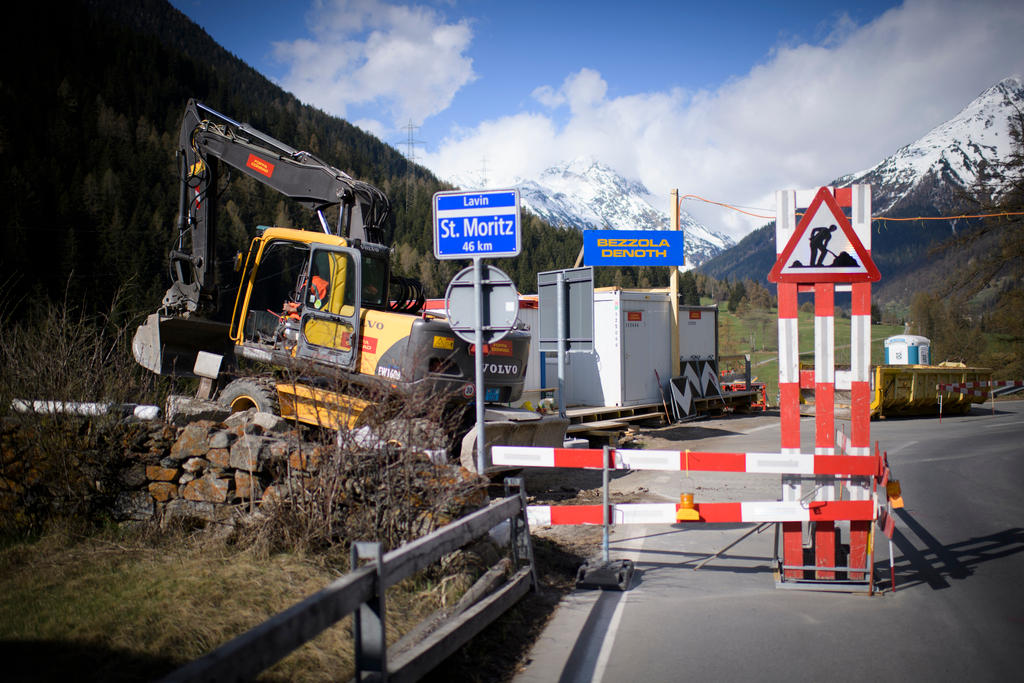 Immagine di strada con una corsia sbarrata; al lato della carreggiata una ruspa in azione e dei container