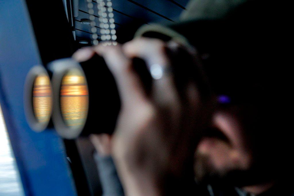 man looking through binoculars