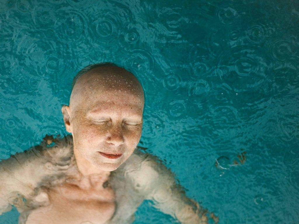 Una mujer sin pelo sumergida en el agua