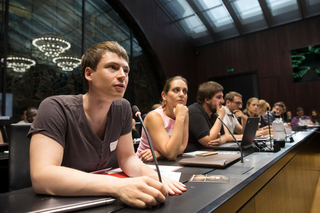 young people sitting at a table in a committee room in the Swiss parliament building