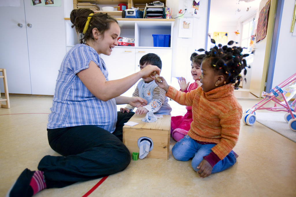 Nursery school teacher playing with children.