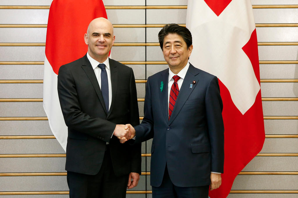 Swiss President Alain Berset shakes hands with Japanese Prime Minister Shinzo Abe